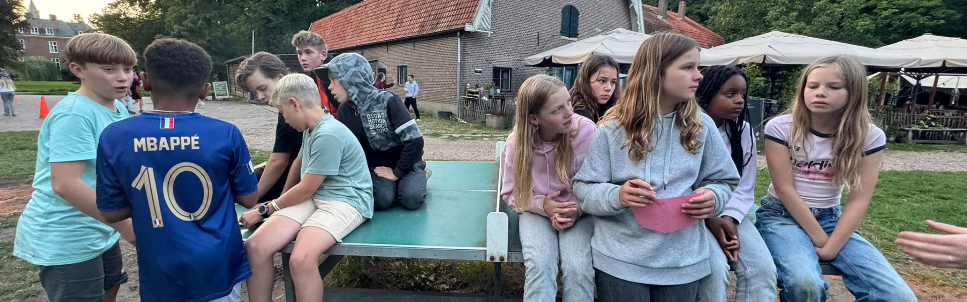 Deelnemers zitten op opblaasbare kussens bij het gebouw