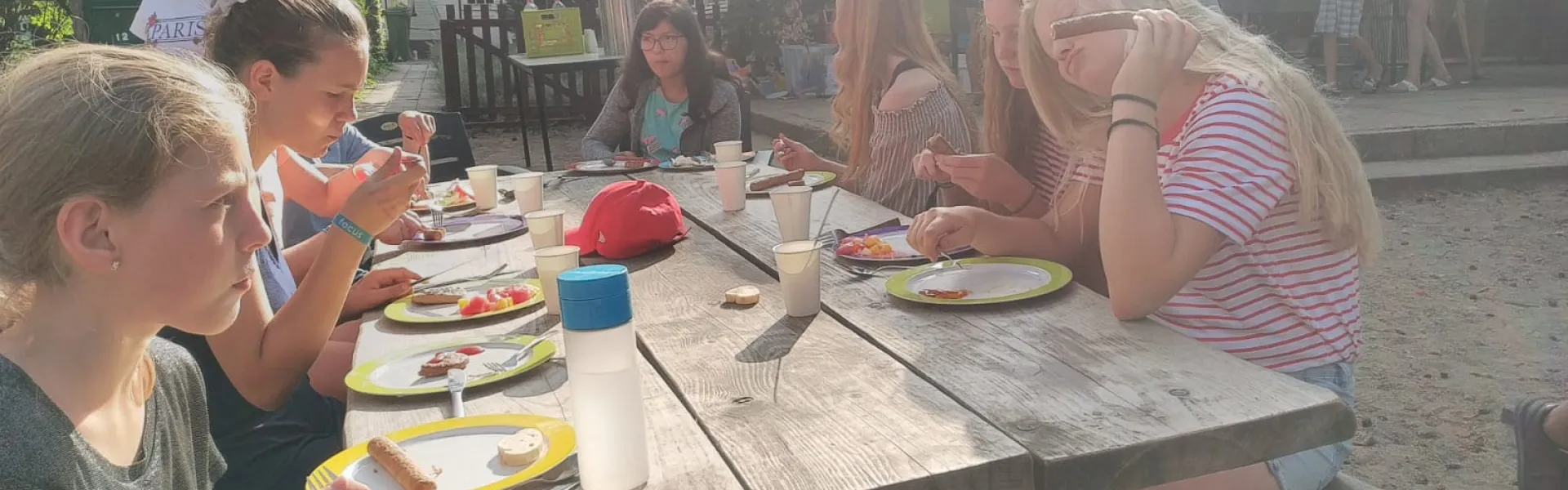 Deelnemers aan een picknicktafel in de zon
