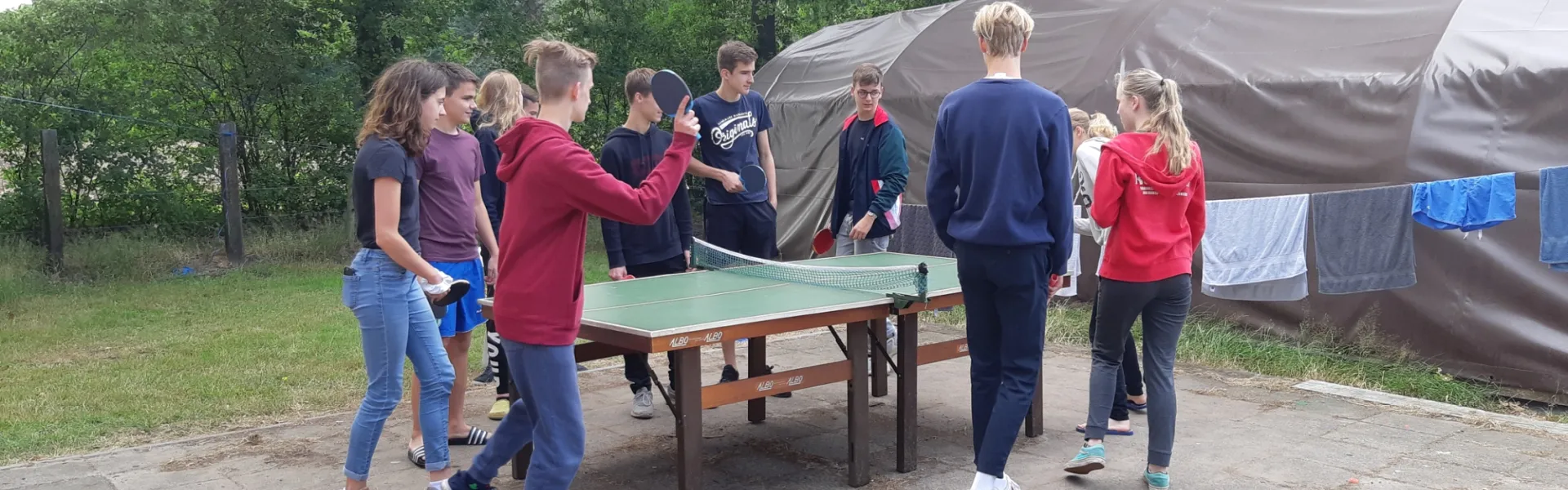 Deelnemers spelen tafeltennis buiten