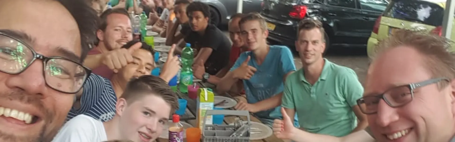 Deelnemers zitten dicht bij elkaar op de foto