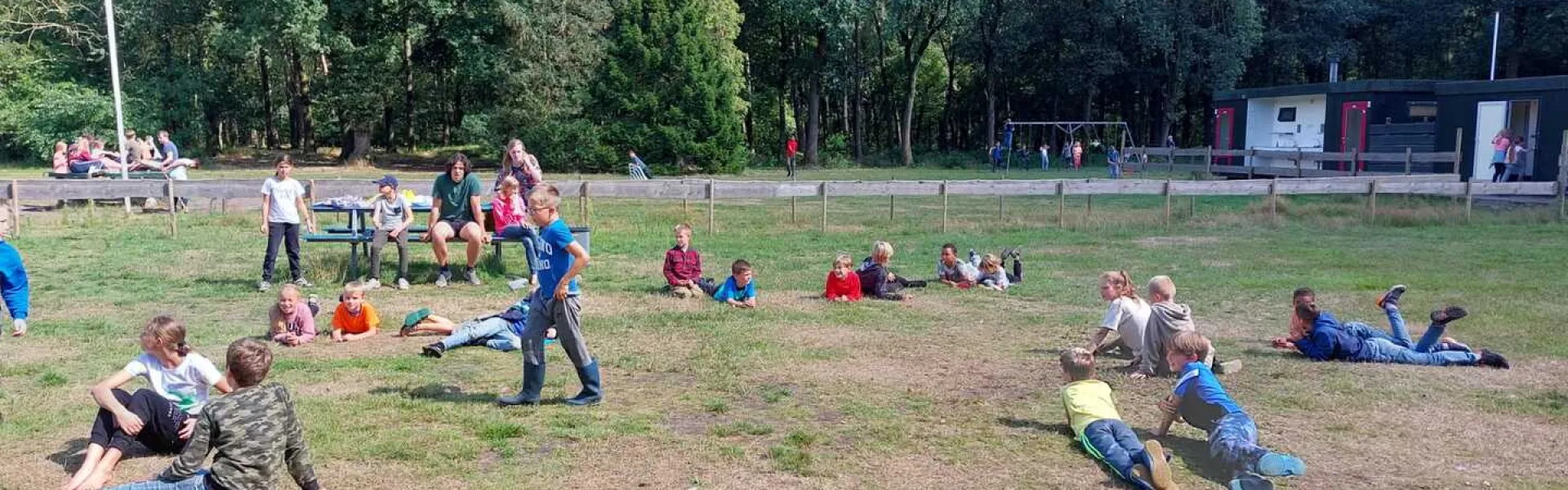 Deelnemers spelen een waterspel op het terrein