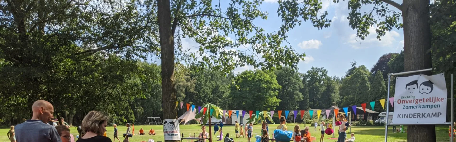 Deelnemers spelen tafeltennis bij het verlichte kampgebouw