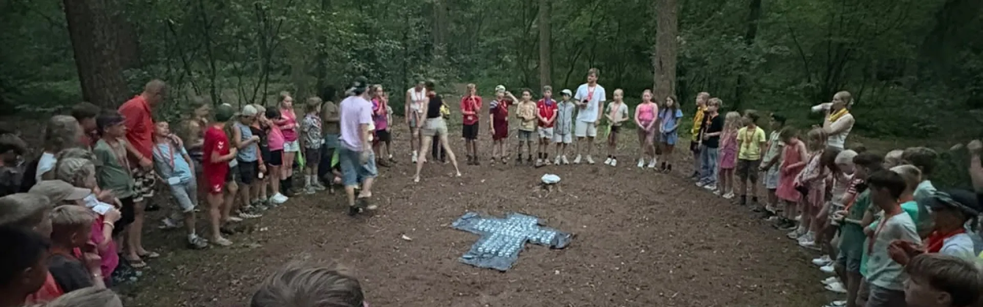 Deelnemers staan in een kring op het zandveld