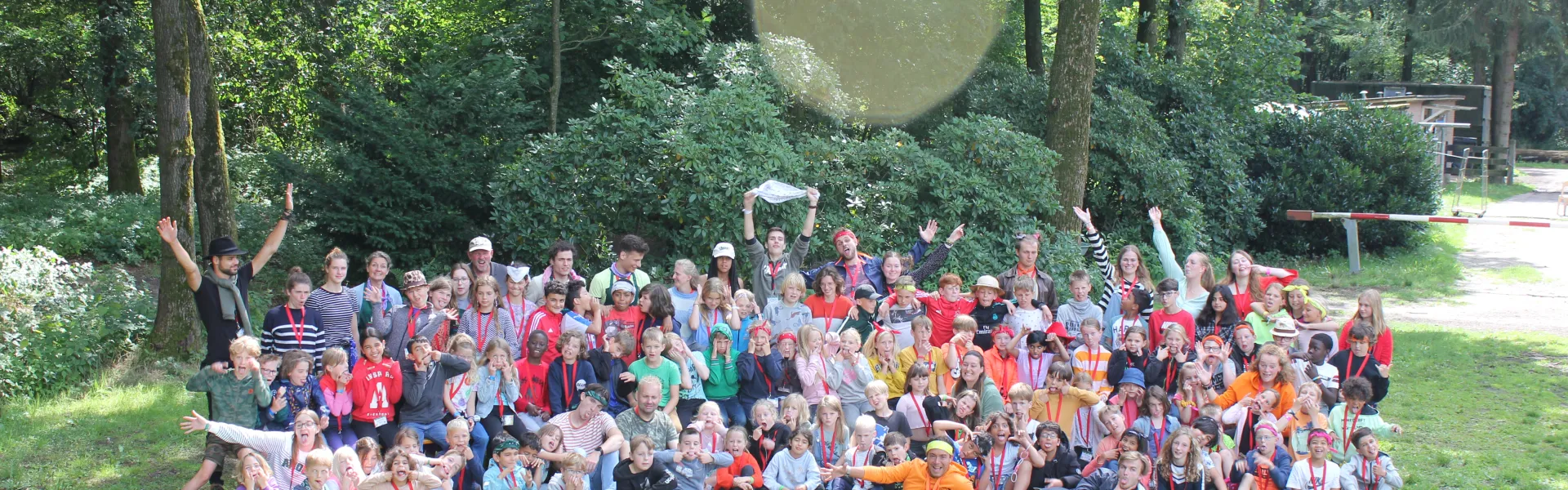 Grote groepsfoto van kinderkamp 2 in het bos