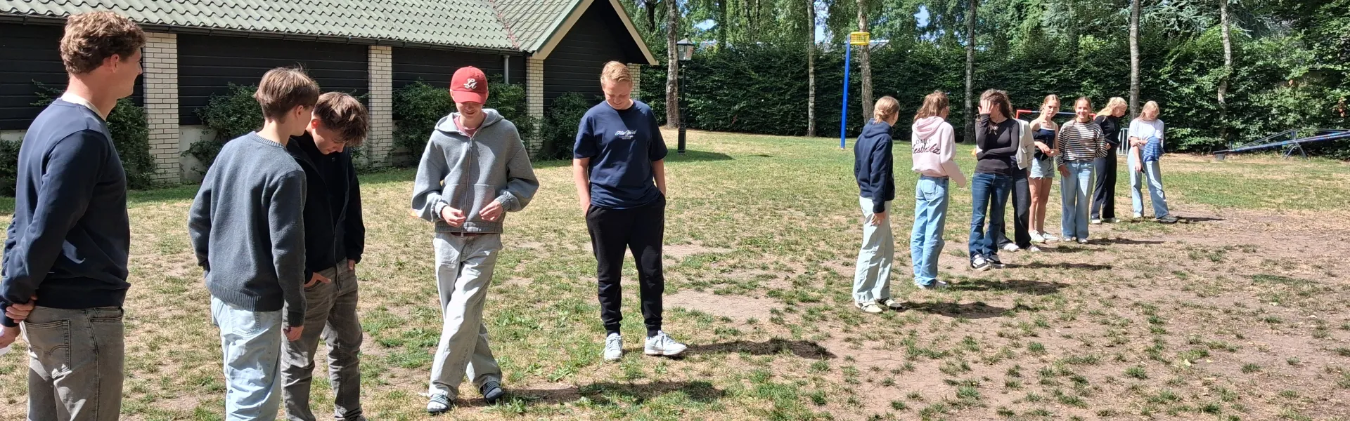 Deelnemers spelen een spel op het zandveld