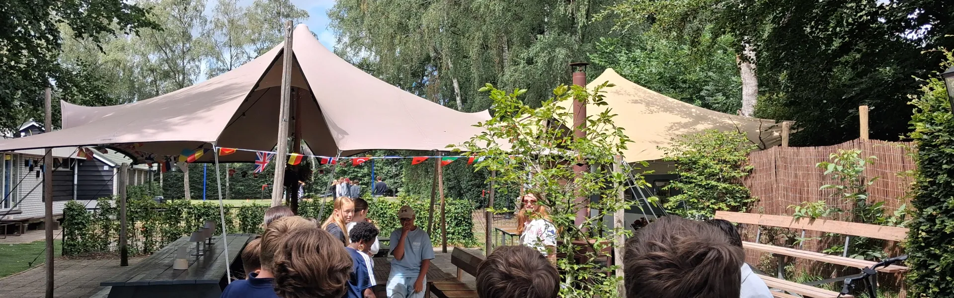 Deelnemers onder een parasol bij het terras