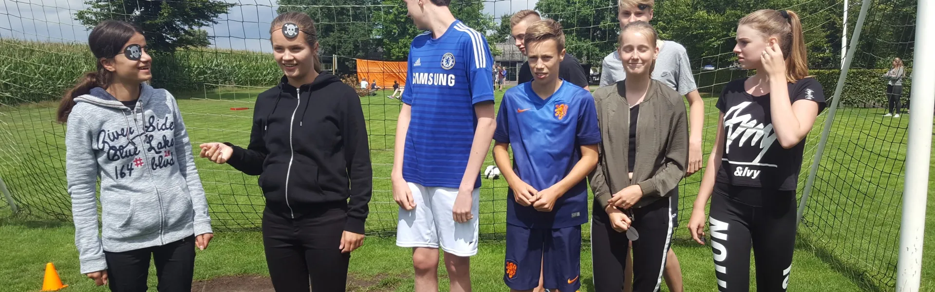 Deelnemers staan bij het doel op het sportveld