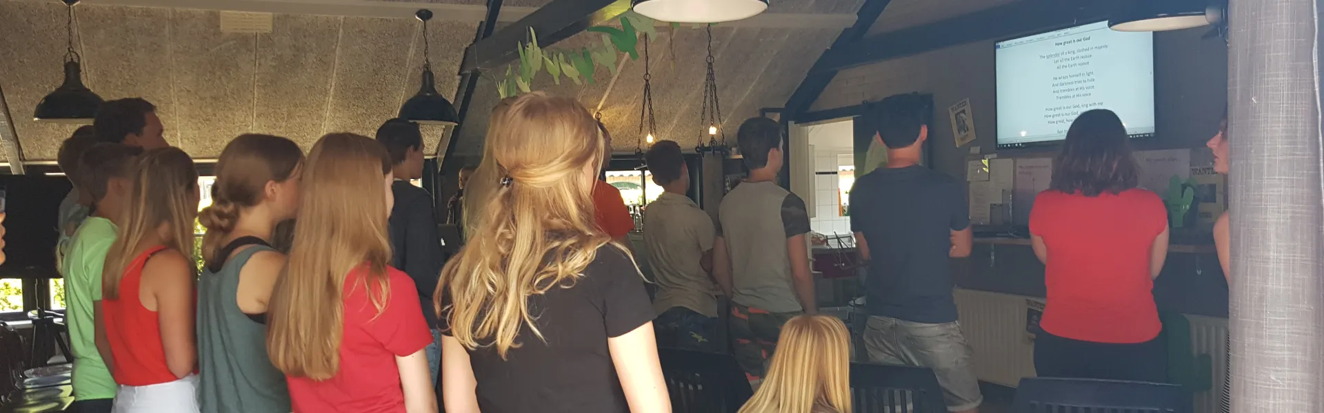 Deelnemers staan te kijken in de zaal
