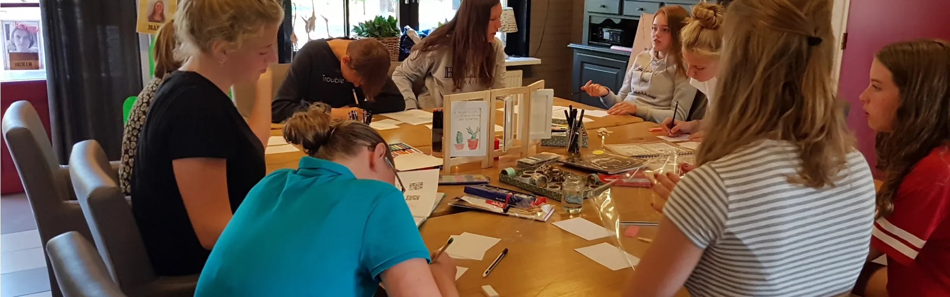 Deelnemers aan tafel in het kampgebouw