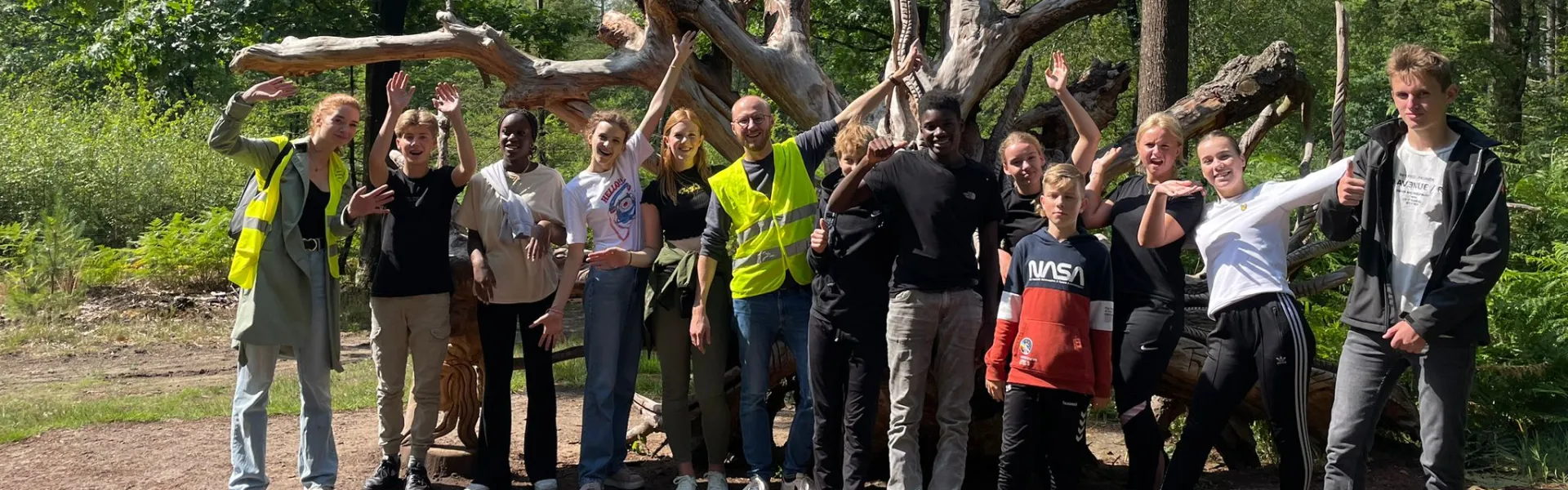 Deelnemers verzamelen zich bij een grote boom
