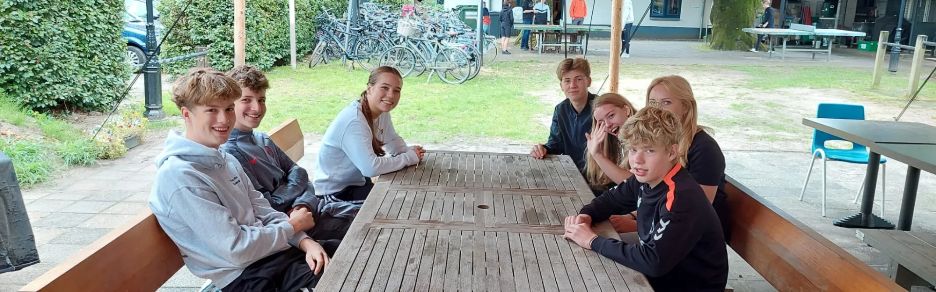 Deelnemers aan picknicktafels onder een luifel