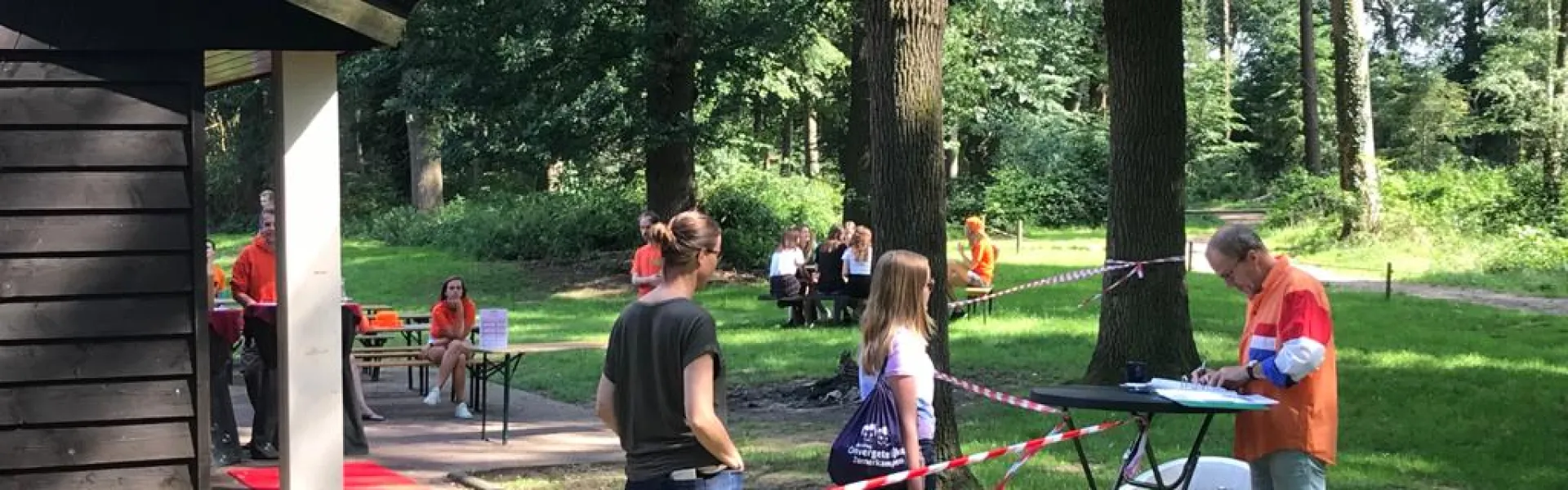 Deelnemers bij het kampgebouw met een rode loper