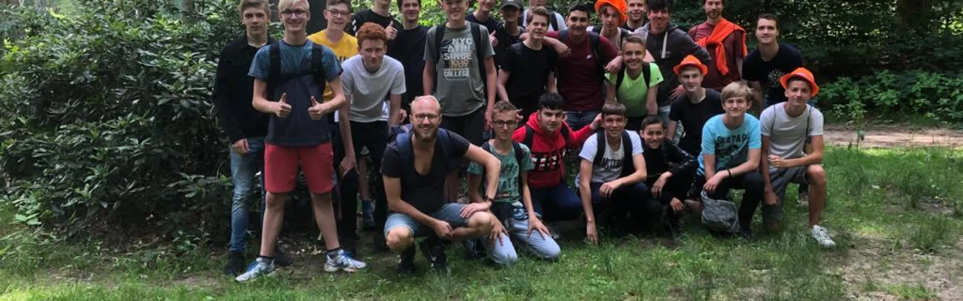 Deelnemers lopen over het terrein langs een tent