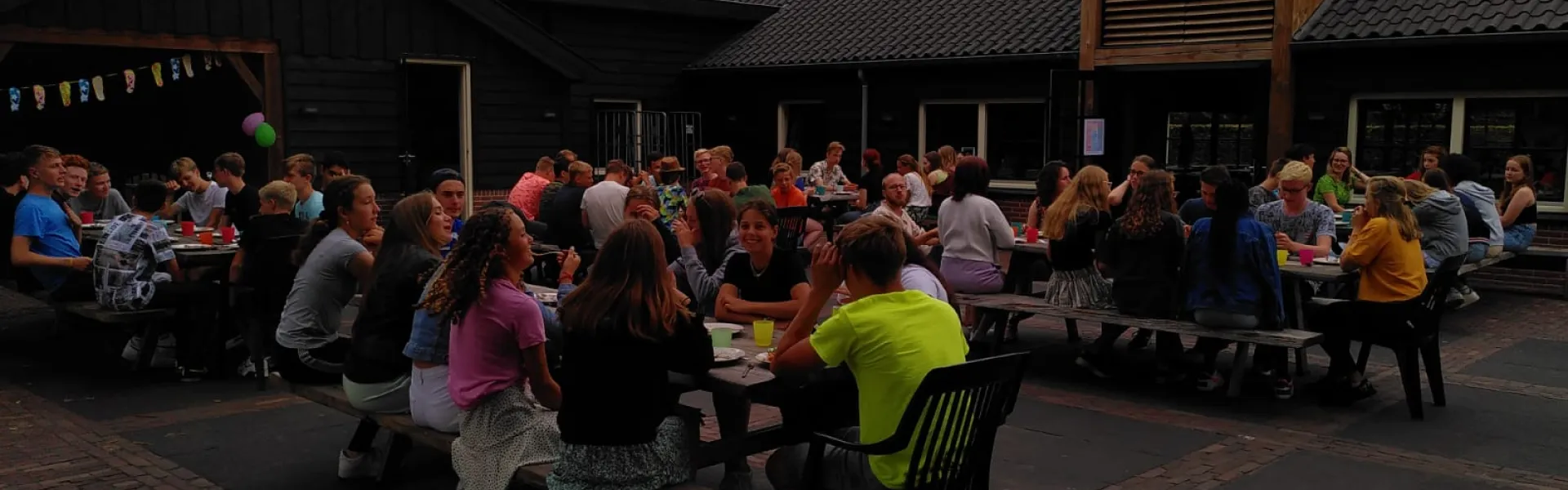 Deelnemers aan tafels op het terras in de avond