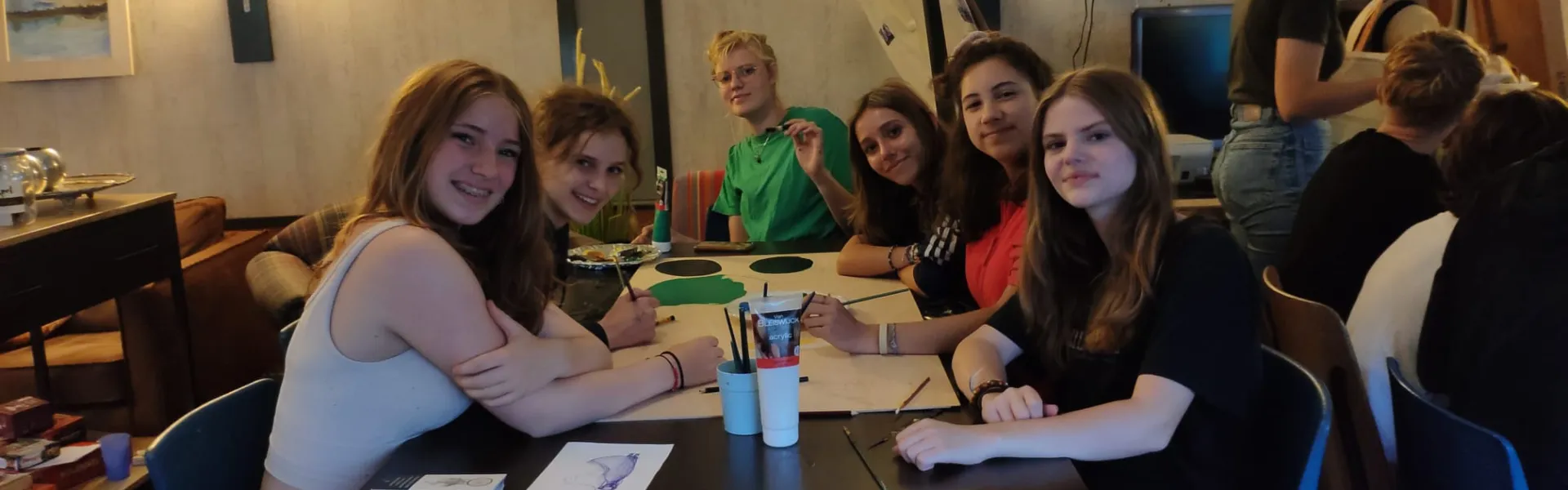 Deelnemers zitten aan tafel in de eetzaal