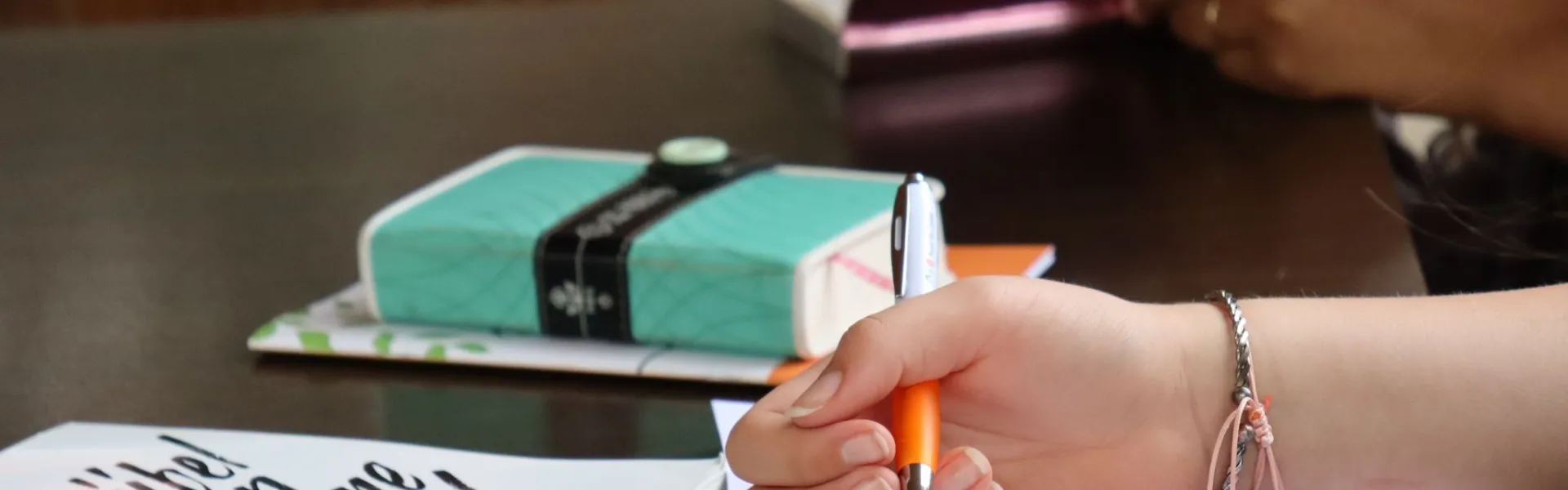 Deelnemer schrijft in een boekje aan tafel