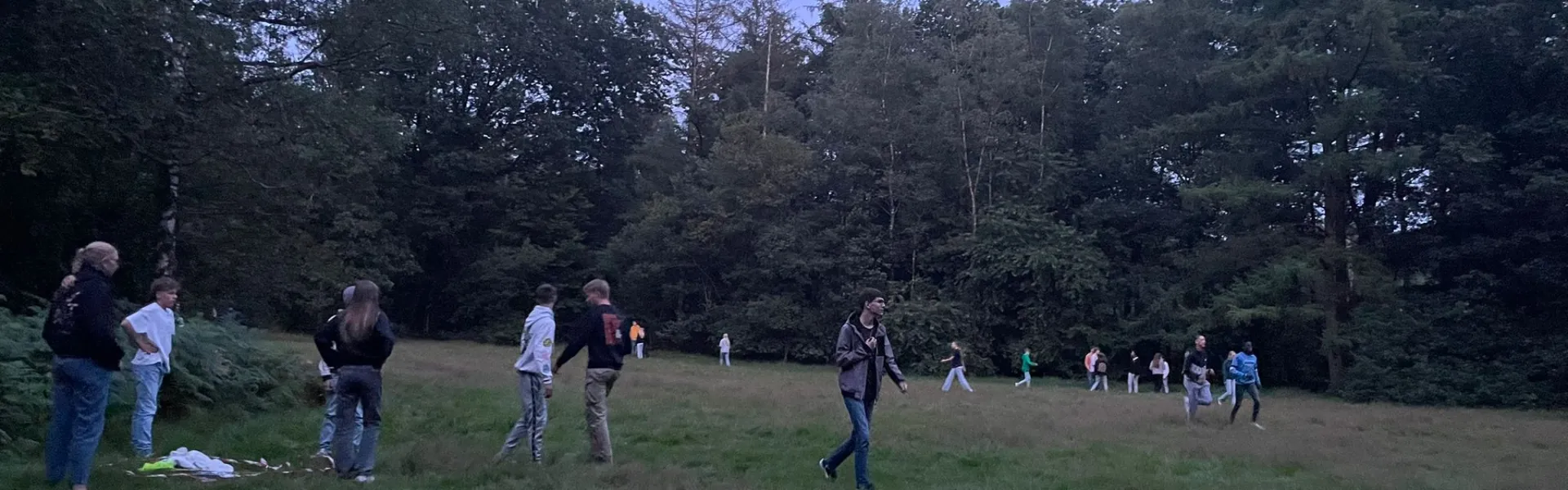 Deelnemers op het grasveld bij schemer