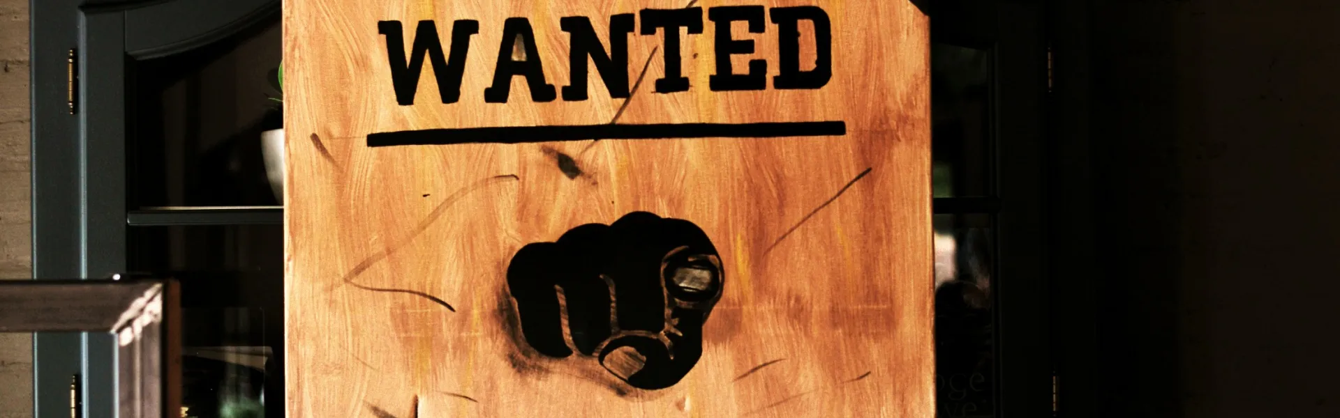 Poster met de tekst WANTED YOU aan de muur