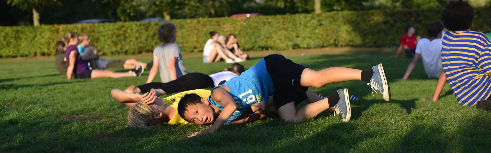 Deelnemers liggen en zitten in het gras
