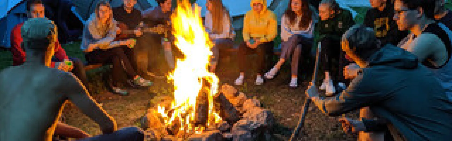 Deelnemers rond een kampvuur