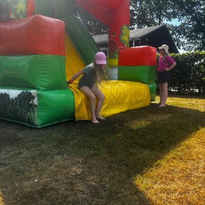 Deelnemers bij een springkussen op het grasveld