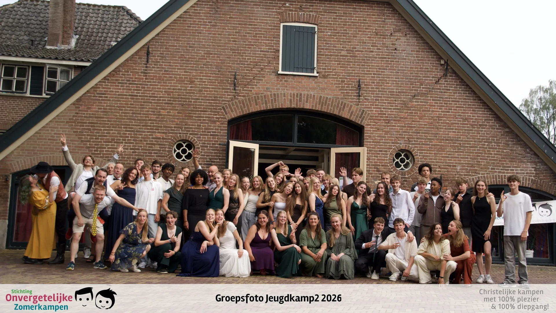Groepsfoto van Jeugdkamp week 2 in 2026, in gala-kleding voor de kampboerderij